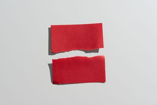 Ripped Sticky Note With Messages Presented On Desk. Teared Apart Memo With Two Different Crutial Information. Recent Announcements Presented.
