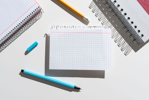 Message Written On Ripped Note On Desk With Pencil And Notebook. Crutial Information Presented On Piece Of Paper On Table With Pen And Notepad.