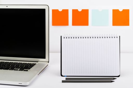 Messages On Notebook And Lap Top On Desk With Notes And Pencils. Crutial Information On Computer Screen And Notepad On Table With Office Supplies.