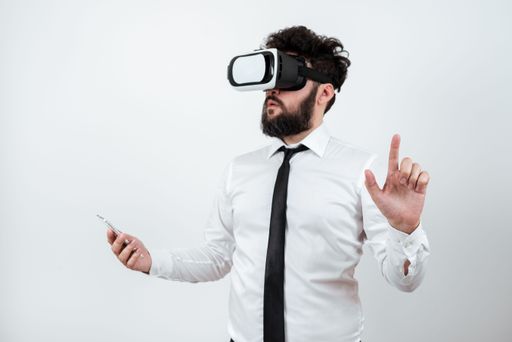 Man Holding Phone, Wearing Vr Glasses And Pointing On With One Finger. Businessman Having Virtual Reality Eyeglasses, Cellphone And Presenting Idea.