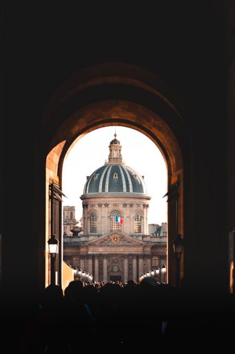 A vertical shot of the Institute of France visible through the arch