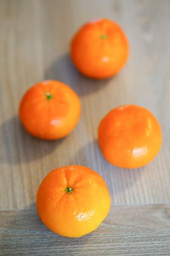 A vertical shot of fresh mandarins on a wooden table