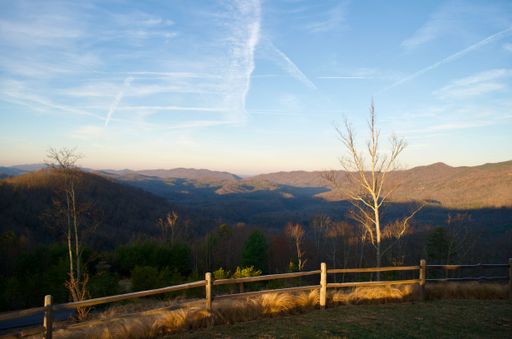 The wooden fence against the background of the mountain range and blue sky.