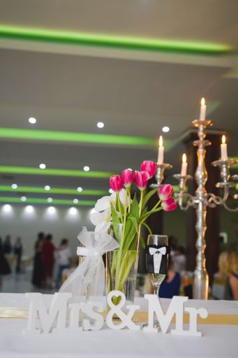 A vertical shot of a Mrs & Mr sign on the table with flowers and champagne during a wedding party