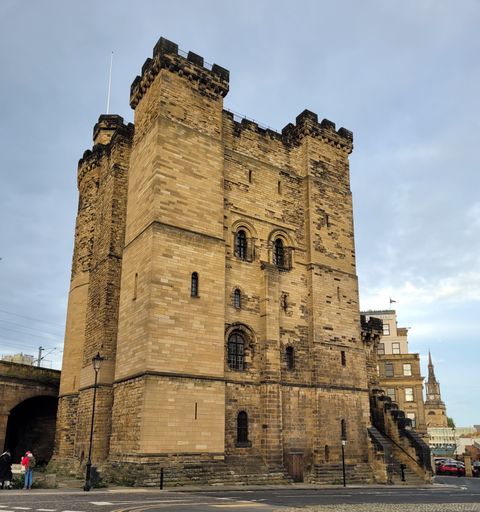 A vertical shot of a medieval Newcastle Castle against a cloudy sky