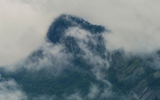 A beautiful shot of the fog covering the rocky mountains
