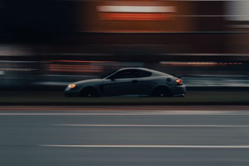 A closeup shot of a modern car riding in the street at night