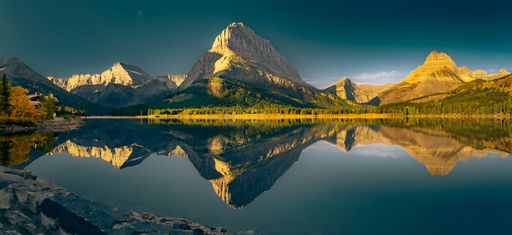 A scenic lake is the centerpiece of the image, surrounded by mountainous peaks