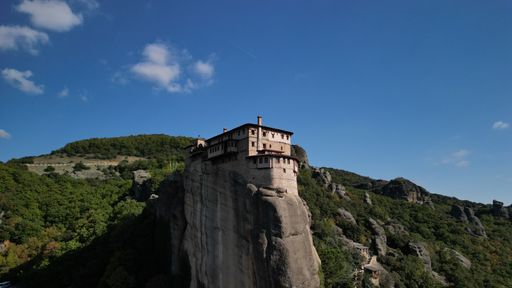 The Rusanu Monastery on the top of a hill surrounded by forests on a sunny day, Greece