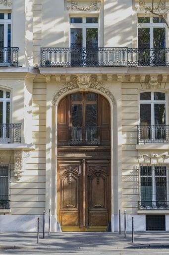 Paris, an ancient wooden door, beautiful facade in a luxury neighborhood, in the 7e arrondissement