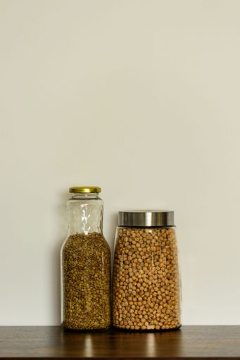 A vertical view of two differently shaped clear glass food storage Canisters placed beside each other