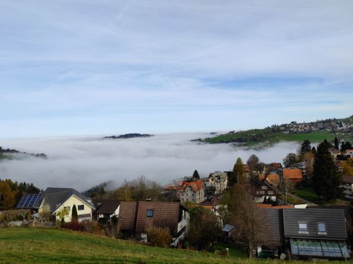 A beautiful shot of a mountain village covered with dense fog in the early morning