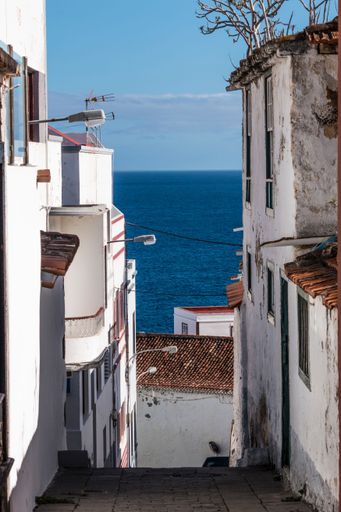 A vertical shot of the pathway between the white walls taking to the beach in Santa Cruz de la Palma, Spain