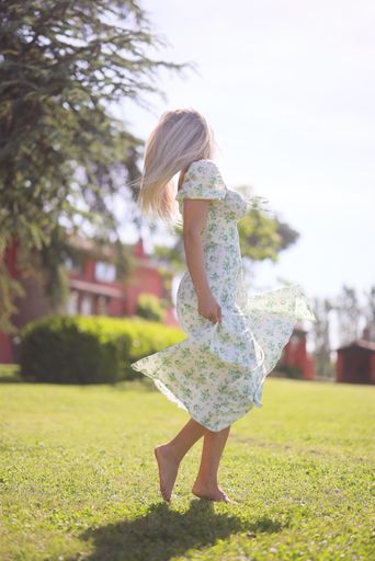 A female wearing dress standing in park