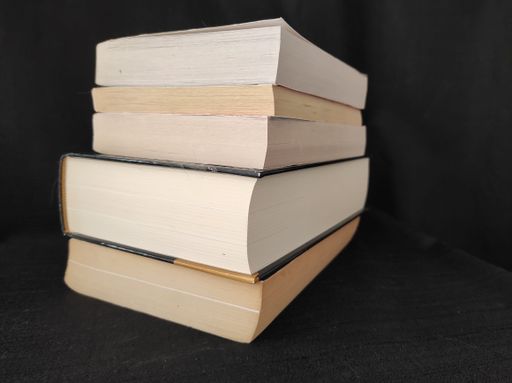 A vertical shot of a pile of books on black background