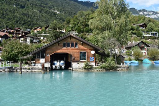 A boat house on Brienz lake with turquoise water in the north of alps in Berne, Switzerland