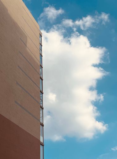 An exterior of a modern building against a cloudy sky