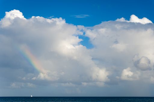 A beautiful shot of a ship in the distance under a cloudy sky