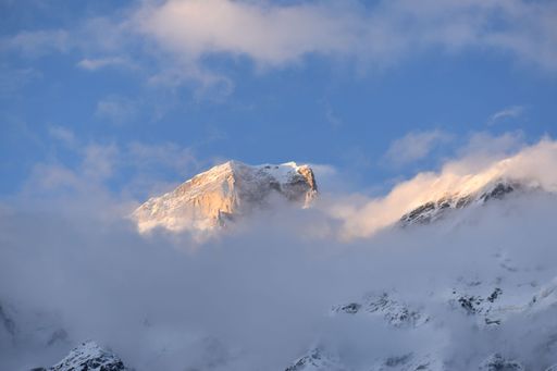 The Garhwal Himalayas snow peaks in the blue sky covered by the floating clouds in India