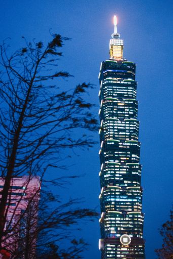 A vertical low angle shot of the illuminated Taipei 101 skyscraper at night in Taipei, Taiwan