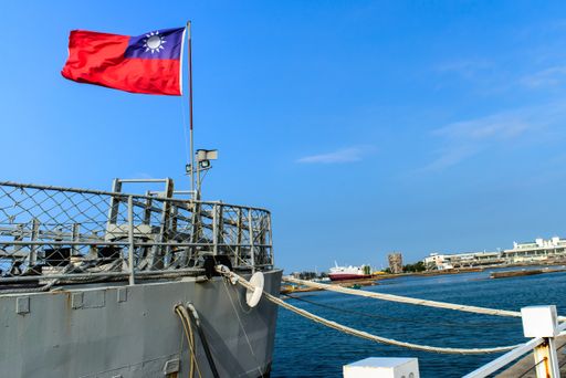 A low angle shot of the Taiwan flag on a white ship in a port under the clear sky
