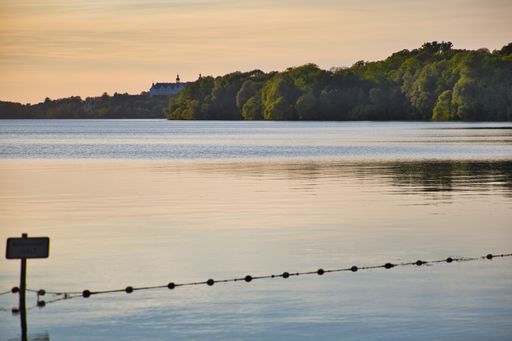 View to Plon castle from beach of Fegetasche, big ploner lake, translation sign: stop, non swimmers, Germany