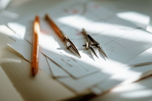 A Vintage drawing tools laying on a stack of paper