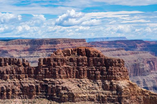 An aerial view of sandstones in Grand Canyon National Park under blue cloudy sky in Arizona