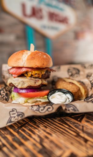 A vertical closeup shot of a tasty burger with meat and bacon