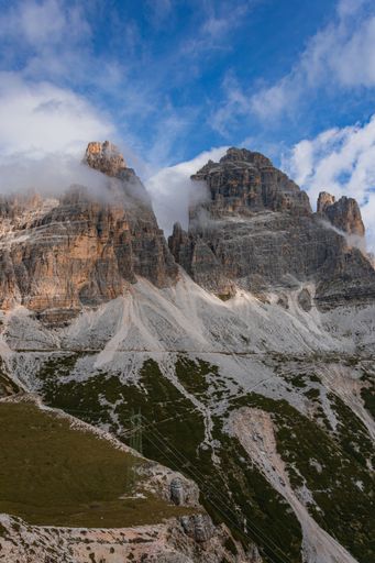 A vertical shot of rocky mountains under cloudy sky
