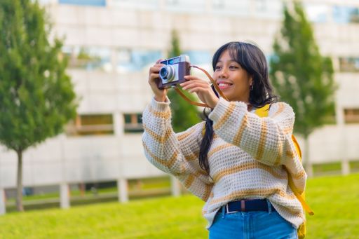 A closeup shot of a young female taking pictures with her vintage camera in a park