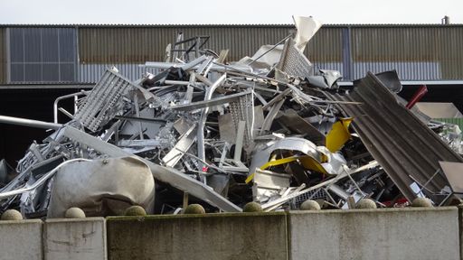 Scrap yard with old iron and sheet metal from cars, appliances, shelves, tin rails and corrugated metal roofing