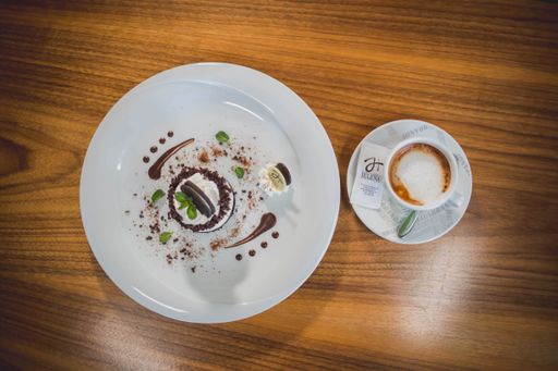 A top view of a no-bake small cheesecake served with a cup of hot coffee on a wooden table
