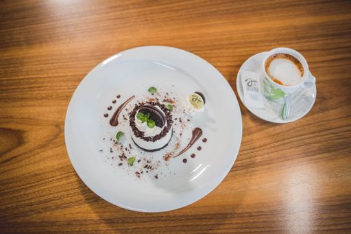 A top view of a no-bake small cheesecake served with a cup of hot coffee on a wooden table