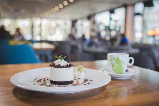 A delicious no-bake small cheesecake served with a cup of coffee in a cozy restaurant