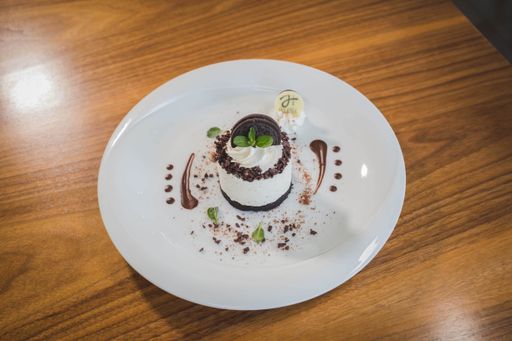 A top view of a no-bake small cheesecake served with a cup of hot coffee on a wooden table