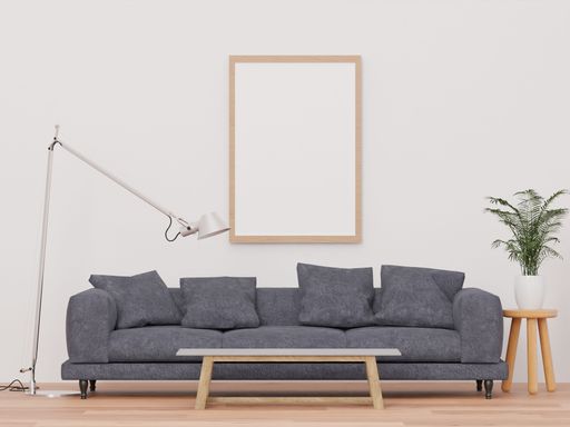 A 3d rendering of a loft-style living room with a white wall, sofa,  mockup frame, and plants.
