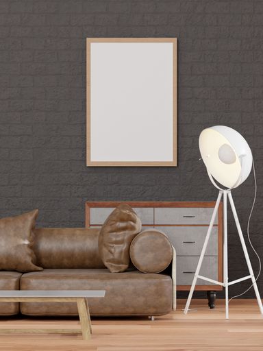 A 3d rendering of a loft-style living room with a black brick wall, sofa,  mockup frame and a drawer.