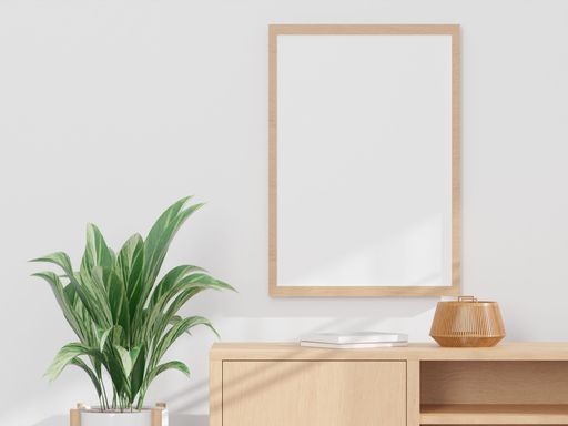 A 3d rendering of a living room with a wooden drawer, a plant and a mock-up frame.
