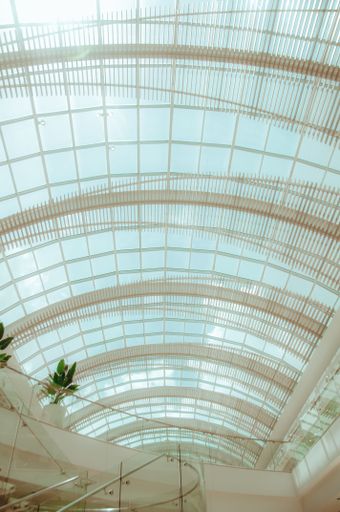 A vertical of a curved metal glass construction of a public roof.