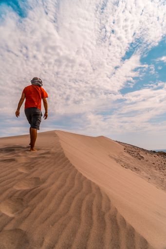 A young man walking with a turban through the desert in Andalucia Spain