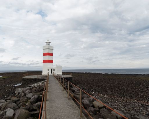 The old Gurdur lighthouse with its red and white color is located on the south coast of Iceland.