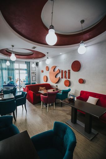 A vertical shot of a cozy modern restaurant interior with comfortable soft chairs and wall decorations