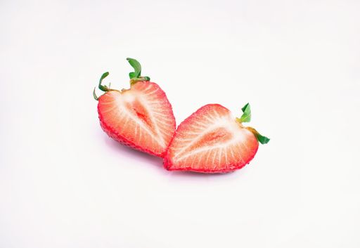 A juicy fresh halved strawberry isolated on a white background