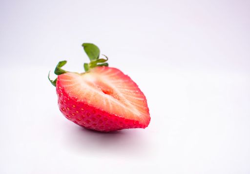 A juicy fresh halved strawberry isolated on a white background