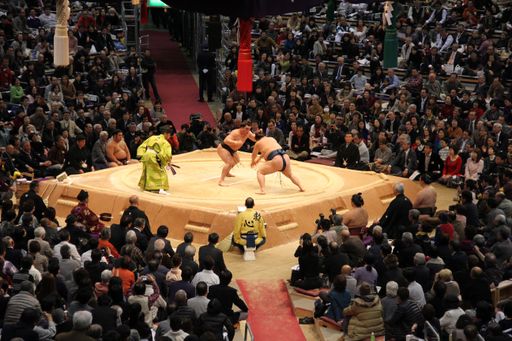 A high angle shot sumo wrestlers compete in a championship in Fukuoka in front of an audience