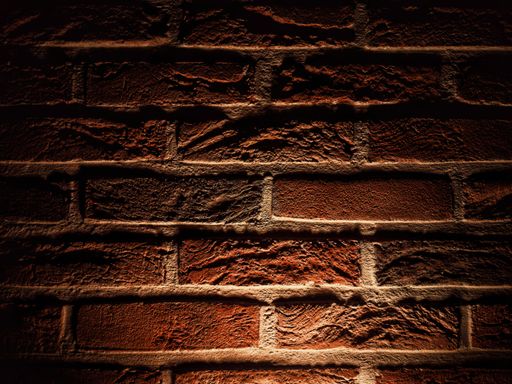 A closeup of a red brick wall with dim lighting - great for backgrounds