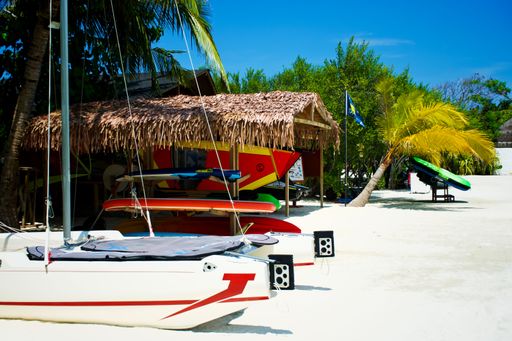 A shack, boats and surfing boards on a beach in Maldives, Huraa