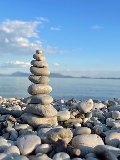 A vertical shot of pebbles sacked in balance at the beach