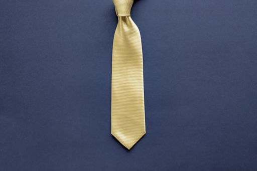 A yellow tie on a dark blue surface